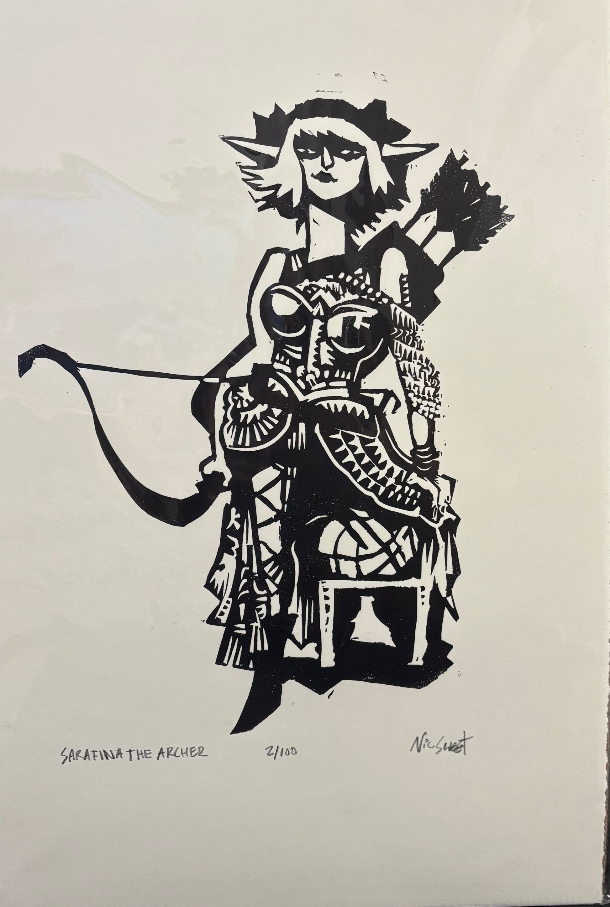 A black and white print of a goddess figure with a bow and arrows, wearing intricate attire, centered on a beige background with a signature at the bottom.
